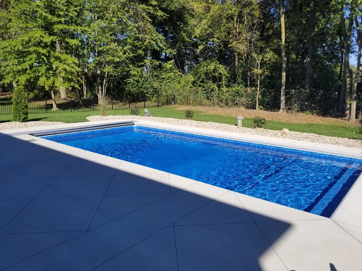 Beautiful rectangular pool against a background of lush, green trees.